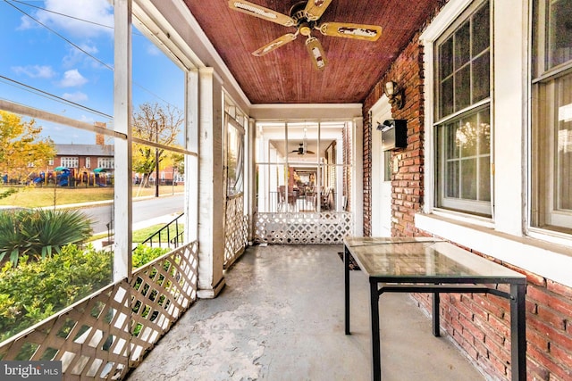 unfurnished sunroom with a wealth of natural light, ceiling fan, and wooden ceiling