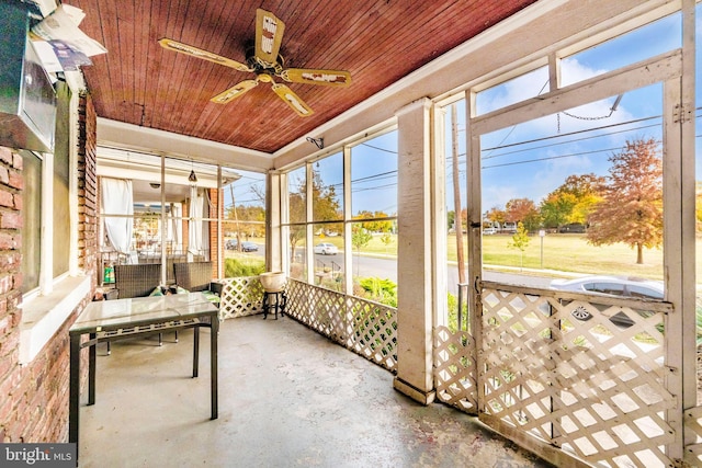 unfurnished sunroom featuring a wealth of natural light, ceiling fan, and wood ceiling