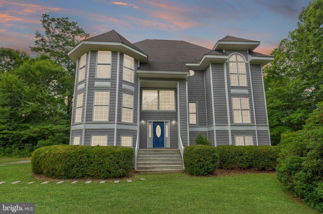 view of front of house with a front lawn and roof with shingles