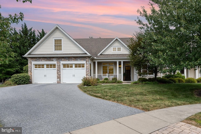 view of front of home featuring covered porch and a yard