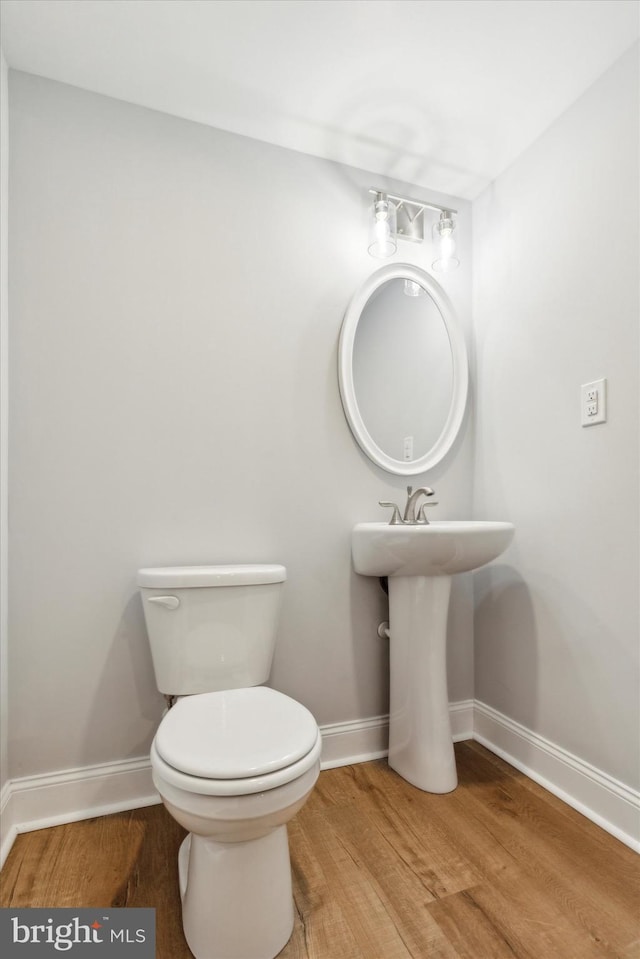 bathroom featuring hardwood / wood-style flooring and toilet