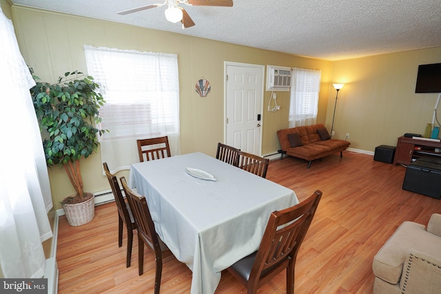 dining space with a wall mounted AC, ceiling fan, a textured ceiling, and light hardwood / wood-style flooring