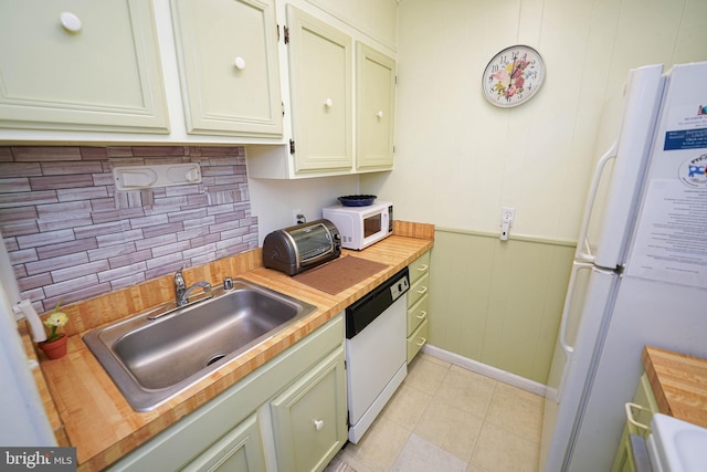 kitchen featuring white appliances, light tile patterned floors, sink, decorative backsplash, and wooden counters