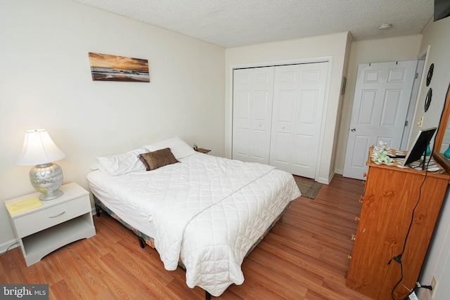 bedroom featuring a textured ceiling, light hardwood / wood-style flooring, and a closet