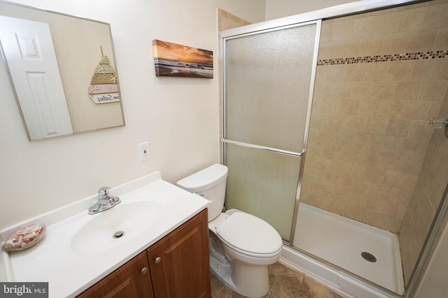 bathroom featuring tile patterned flooring, vanity, toilet, and an enclosed shower