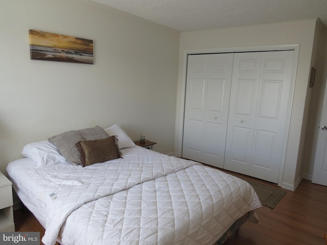 bedroom with a closet, hardwood / wood-style floors, and a textured ceiling