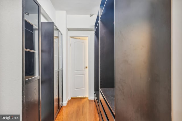 hall featuring light wood-style floors and baseboards