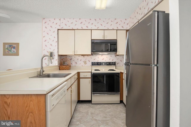 kitchen featuring light tile patterned floors, kitchen peninsula, cream cabinets, and white appliances