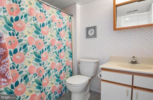 bathroom with toilet, a paneled ceiling, vanity, visible vents, and wallpapered walls