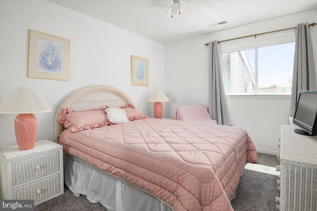 carpeted bedroom with ceiling fan and a textured ceiling