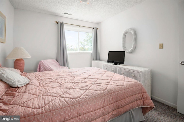 carpeted bedroom with a textured ceiling