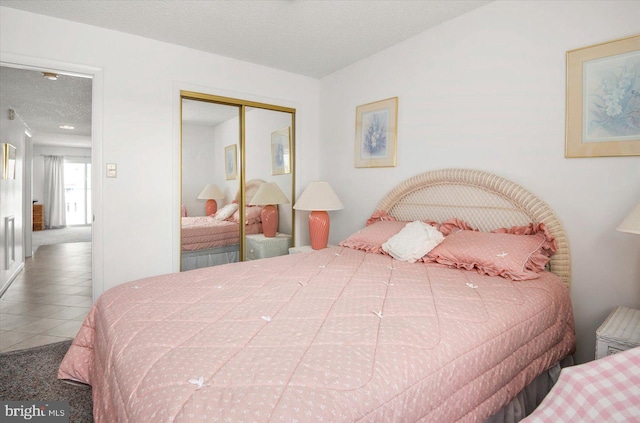 tiled bedroom featuring a closet and a textured ceiling