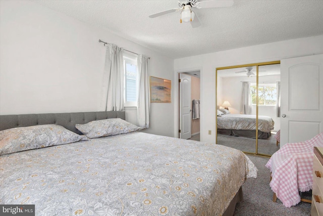 carpeted bedroom featuring ceiling fan, a closet, a textured ceiling, and multiple windows