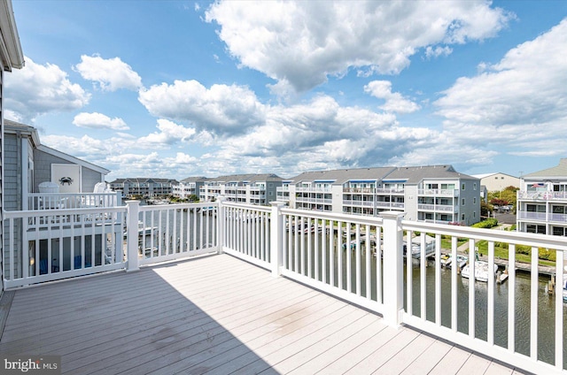 wooden terrace with a water view and a residential view