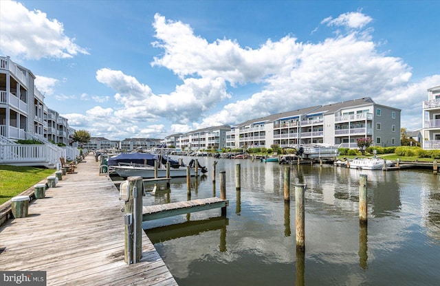 view of dock with a balcony and a water view