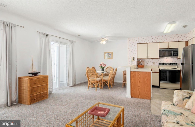 living room featuring ceiling fan, sink, a textured ceiling, and light carpet