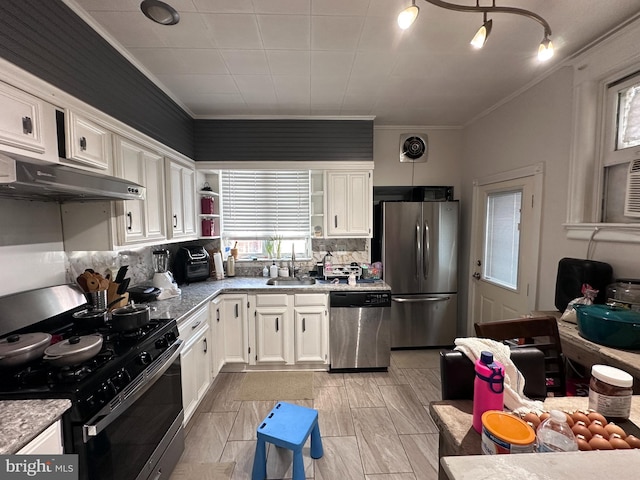 kitchen with stainless steel appliances, white cabinetry, tasteful backsplash, sink, and crown molding