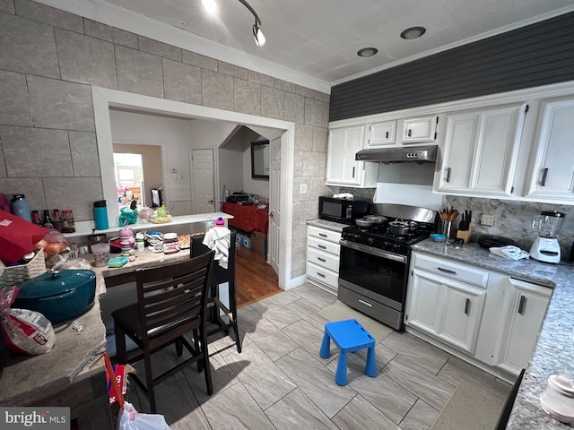 kitchen with white cabinetry, light stone counters, crown molding, light wood-type flooring, and stainless steel range with gas cooktop