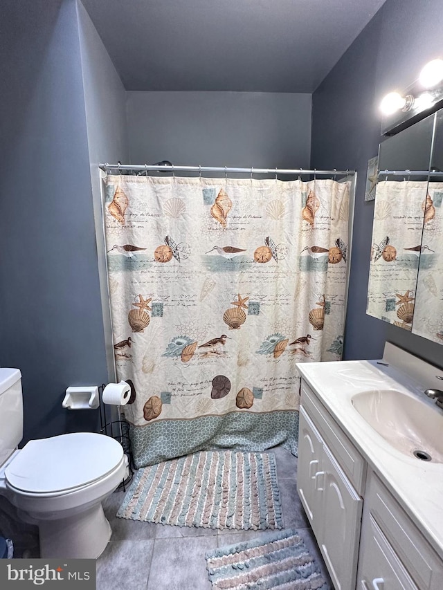 bathroom with tile patterned flooring, vanity, and toilet