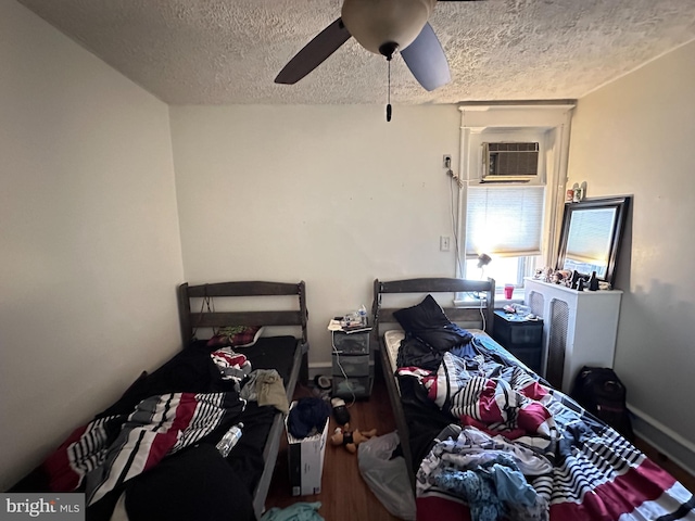 bedroom with ceiling fan, a textured ceiling, and a wall mounted AC