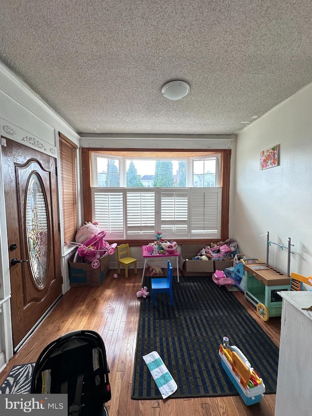 interior space with a textured ceiling, a healthy amount of sunlight, and wood-type flooring