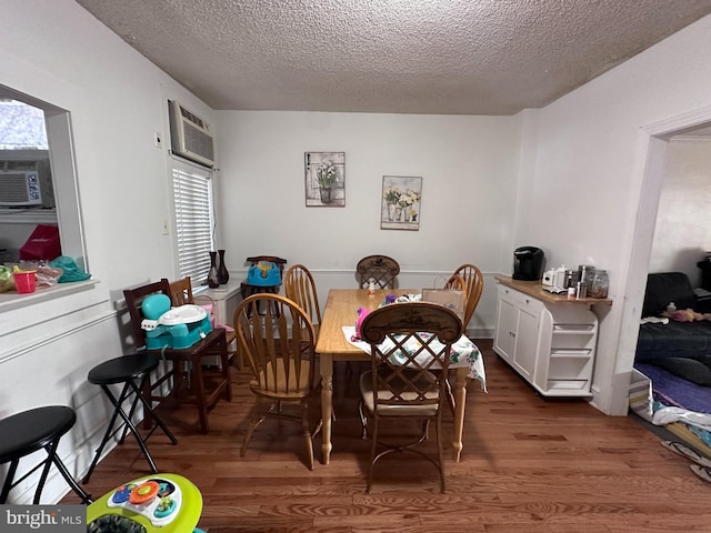 dining space featuring hardwood / wood-style floors, a textured ceiling, and a wall mounted AC