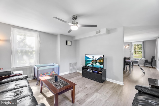 living room featuring light hardwood / wood-style floors and ceiling fan