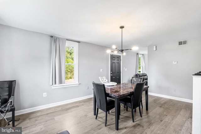 dining space featuring a chandelier and light wood-type flooring