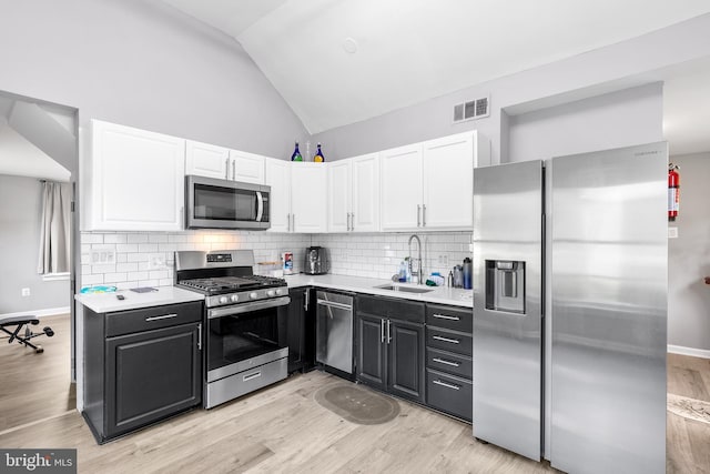 kitchen featuring decorative backsplash, light hardwood / wood-style flooring, and appliances with stainless steel finishes