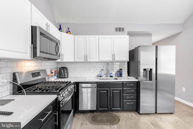 kitchen featuring light hardwood / wood-style floors, appliances with stainless steel finishes, sink, and white cabinets