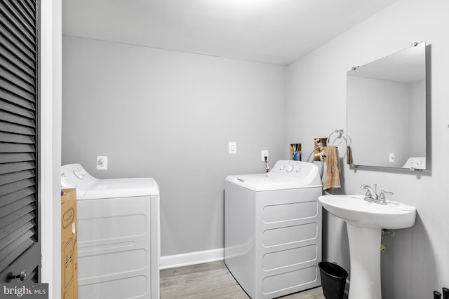 laundry room featuring washer and clothes dryer and hardwood / wood-style flooring