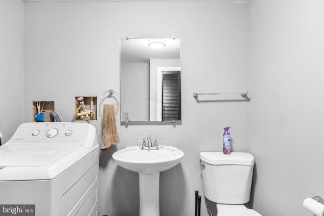 bathroom featuring toilet and washer / dryer