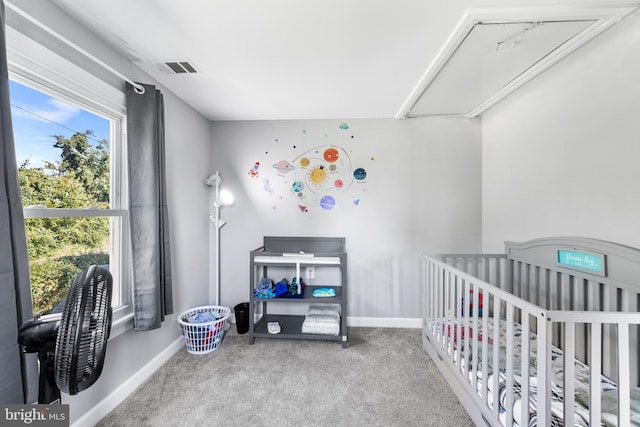 carpeted bedroom featuring a nursery area