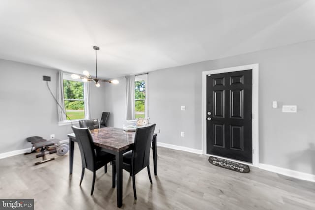 dining space featuring hardwood / wood-style flooring and an inviting chandelier