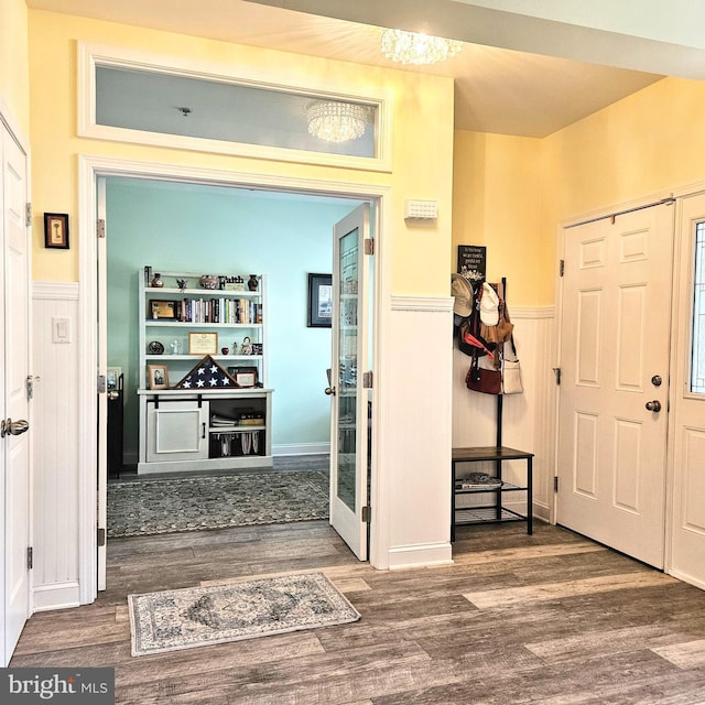 foyer entrance featuring a wainscoted wall and dark wood-type flooring