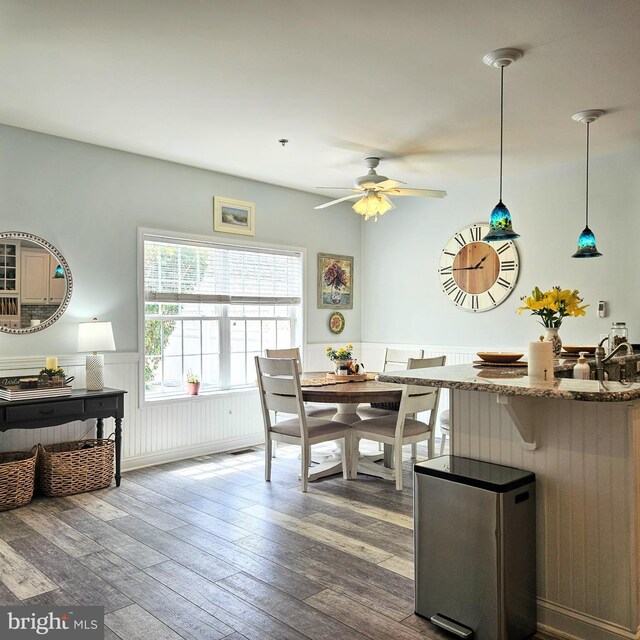 dining space with ceiling fan and hardwood / wood-style flooring