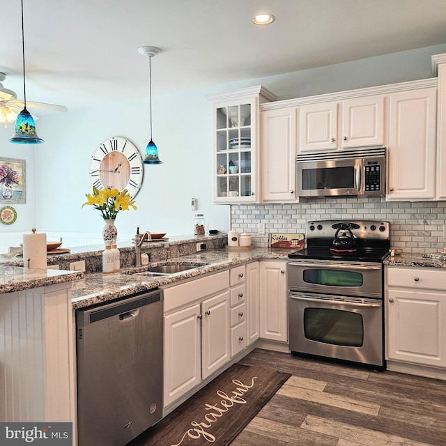 kitchen featuring stainless steel appliances, pendant lighting, and white cabinets