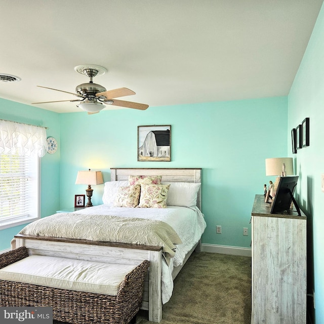 bedroom with dark colored carpet, a ceiling fan, visible vents, and baseboards