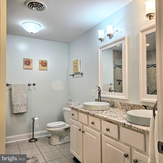 bathroom with tile patterned flooring, toilet, a sink, visible vents, and double vanity