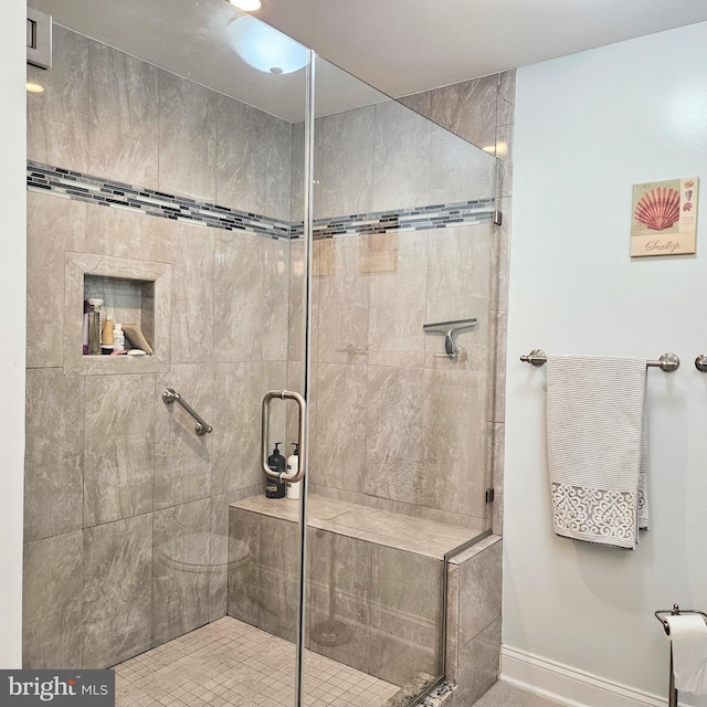 bathroom featuring a tile shower and baseboards