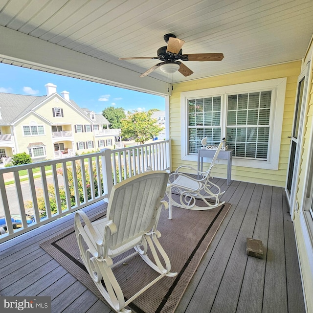 wooden terrace featuring ceiling fan and a residential view