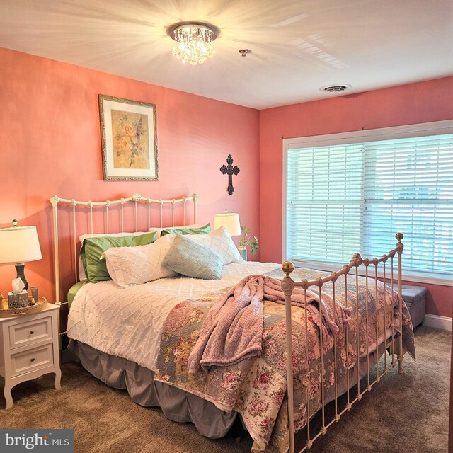 carpeted bedroom with multiple windows and a chandelier