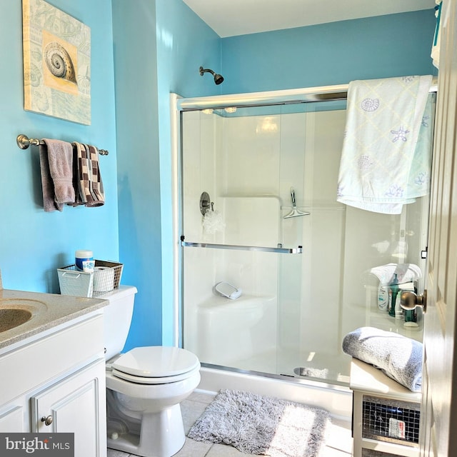 bathroom featuring toilet, walk in shower, tile patterned flooring, and vanity