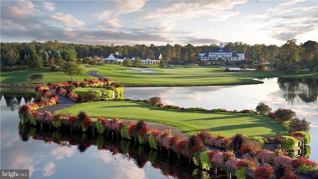 view of community featuring a water view, golf course view, and a lawn