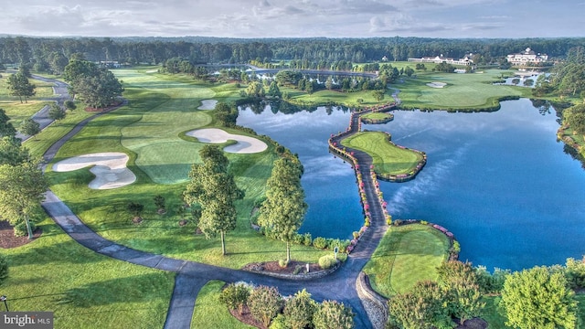 drone / aerial view with view of golf course and a water view