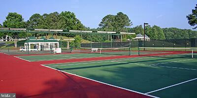 view of tennis court with community basketball court and fence