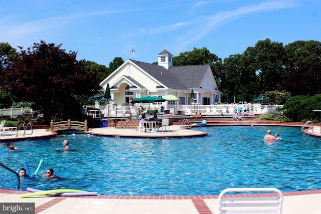 community pool featuring fence and a patio