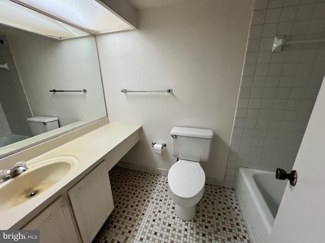 full bathroom featuring toilet, tiled shower / bath combo, vanity, and tile patterned floors