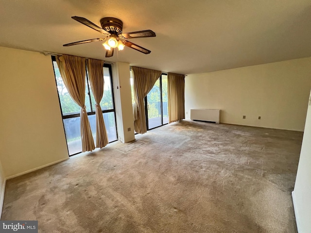 unfurnished room featuring a wealth of natural light, carpet floors, and ceiling fan