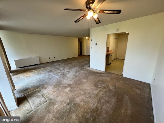 carpeted empty room with radiator heating unit and ceiling fan